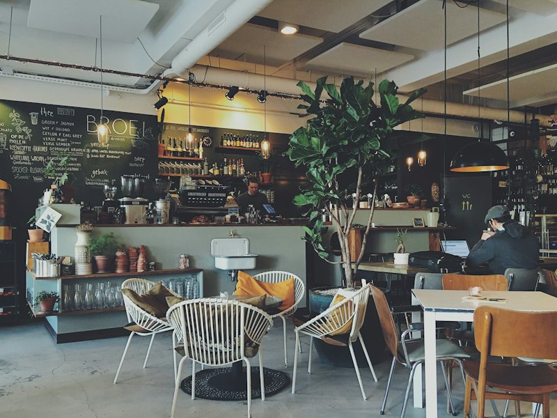 Café interior with plants and wooden tables